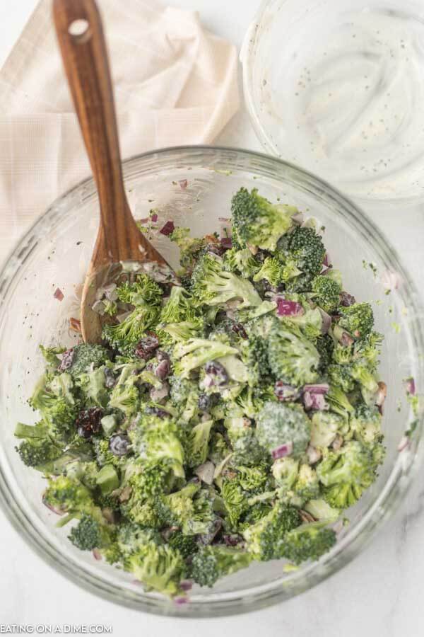 mixing dressing and broccoli salad ingredients together