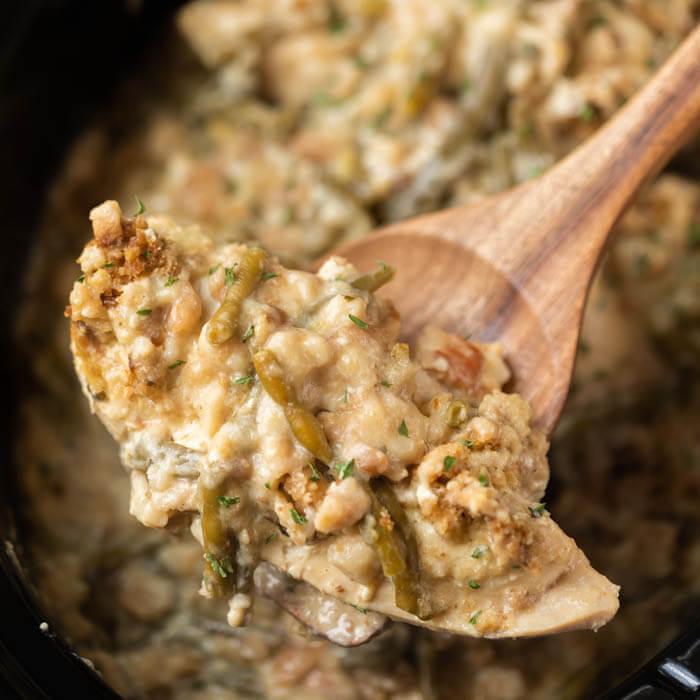 Close up image of chicken and stuffing on a brown spoon. 