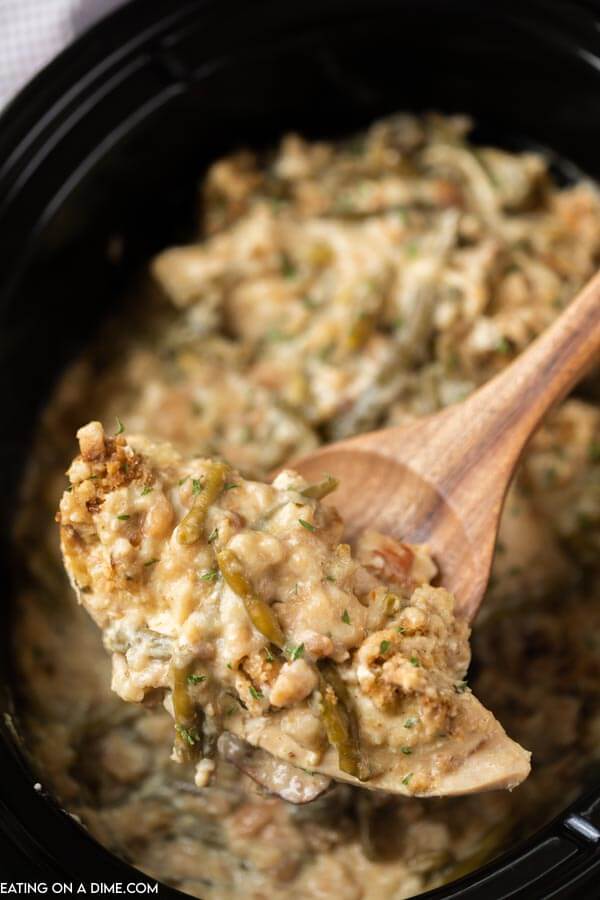 Close up image of chicken and stuffing on a brown spoon. 
