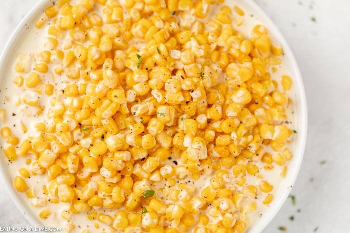 Close up image of creamed corn in a white bowl. 