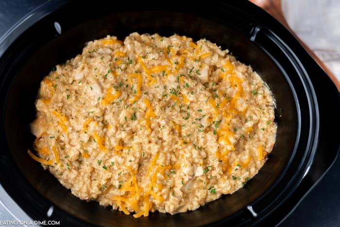 Overview of this cheesy chicken and rice in a black crock pot. 