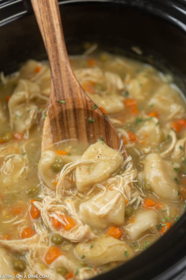 chicken and dumplings in crock pot with wooden spoon