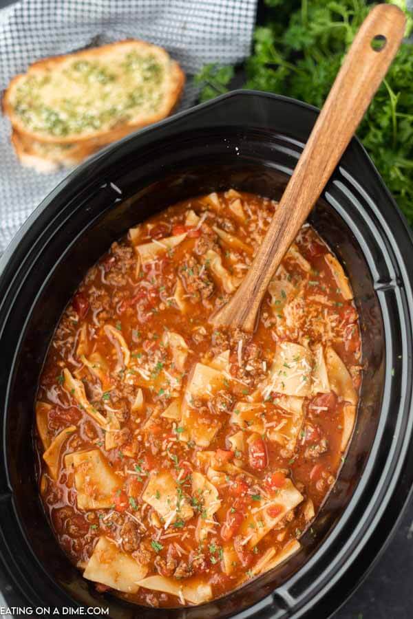 Lasagna Soup in a crock pot with a wooden spoon in it for serving. 