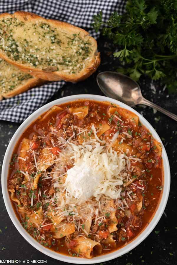 A bowl of the lasagna soup topped with ricotta cheese and parmesan cheese.  