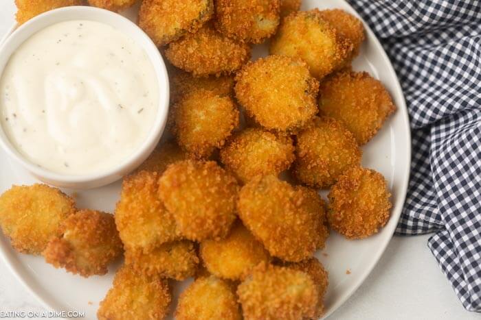 fried pickles on a plate with ranch dipping sauce