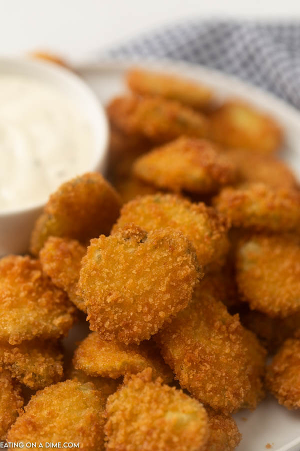 fried pickles on a plate with ranch for dipping