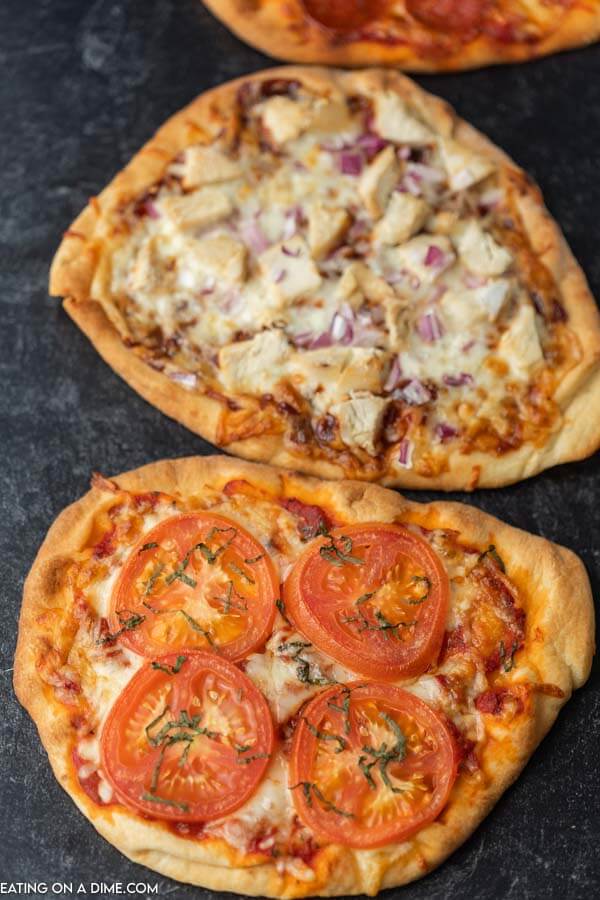 Close up photo of 3 flatbread pizzas.