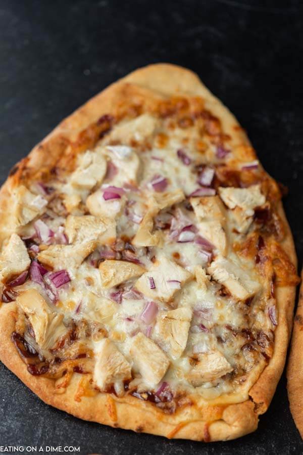 Close up image of a pizza with chicken and red onions. 
