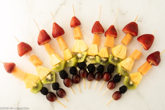 Fruit Kabobs laid out in the shape of a rainbow 