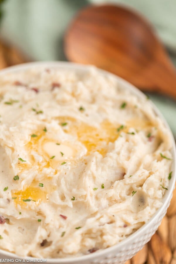 Bowl of mashed potatoes topped with butter. 