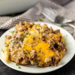 Cheesy potato casserole on a white plate.