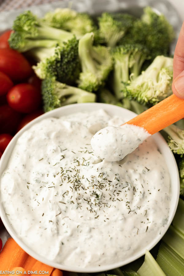 ranch dip in a bowl with carrots, broccoli and cherry tomatoes
