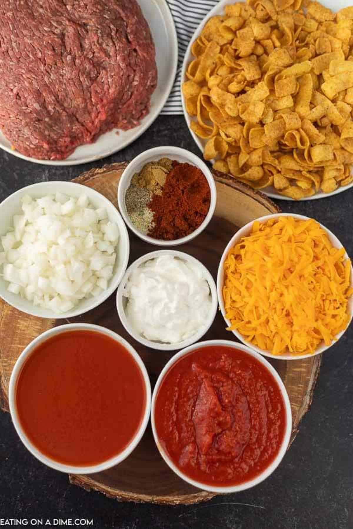 Ingredients to make Instant Pot Frito Chili Pie Recipe: Ground Beef, Beef Broth, diced onions, minced garlic, pinto beans, chili powder, tomato sauce, cumin, salt, pepper and diced tomatoes 