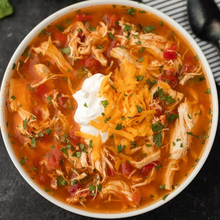 Close up bowl of chicken fajita soup in a white bowl. 