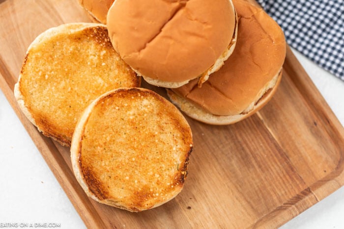 toasted hamburger buns on a cutting board