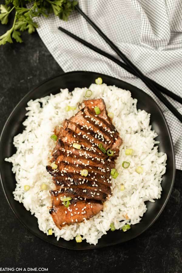 steak served on a plate of rice