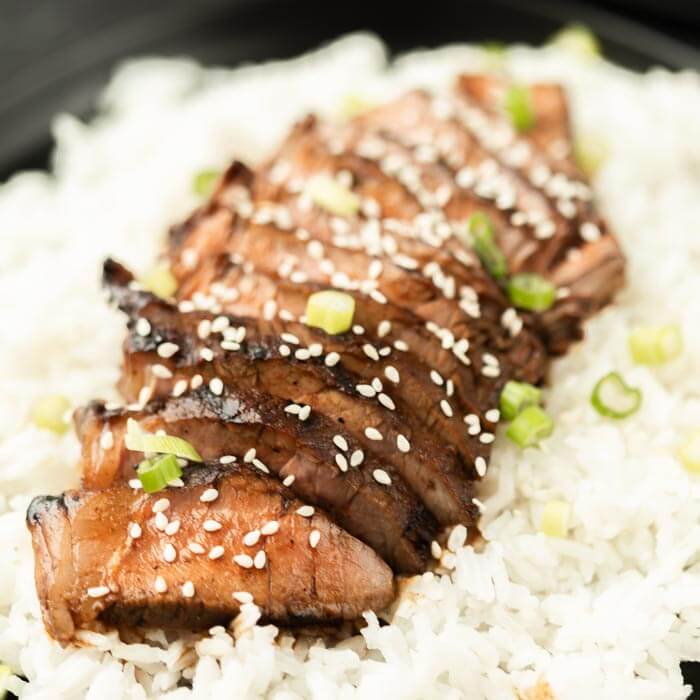 close up photo of steak over rice