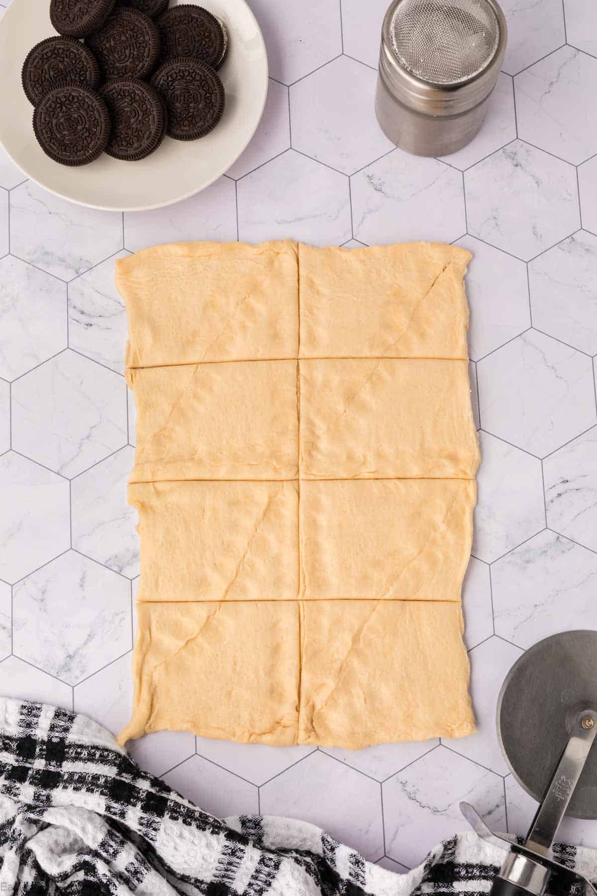 Crescent Roll Dough rolled our with a plate of Oreos on the side