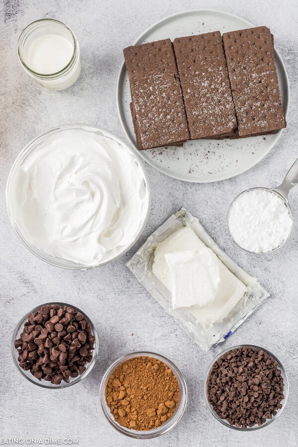 Ingredients needed - chocolate graham crackers, cream cheese, powdered sugar, cocoa powder, cool whip, heavy whipping cream, chocolate chips