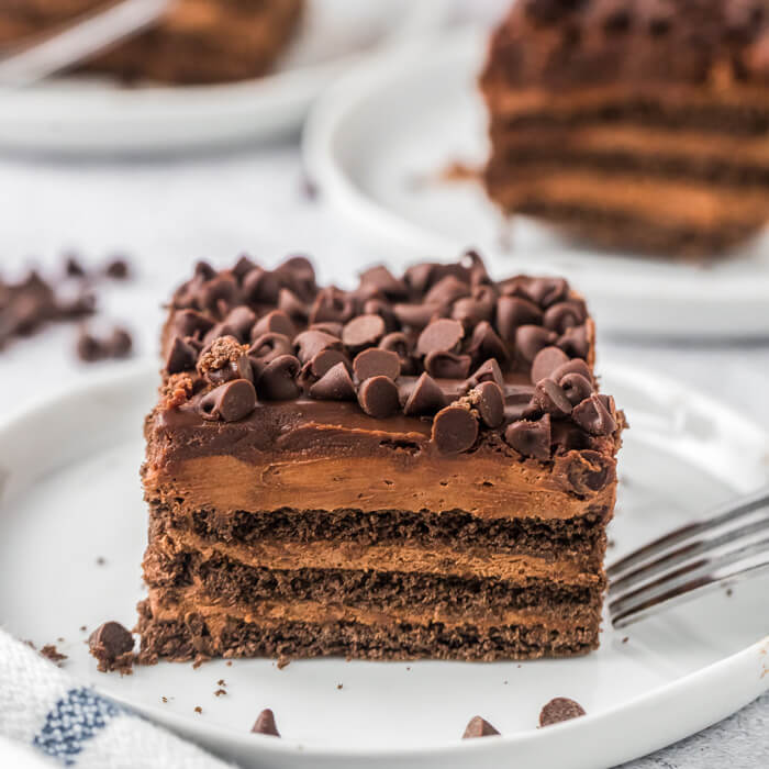 Close up image of a piece of chocolate icebox cake on a white plate. 