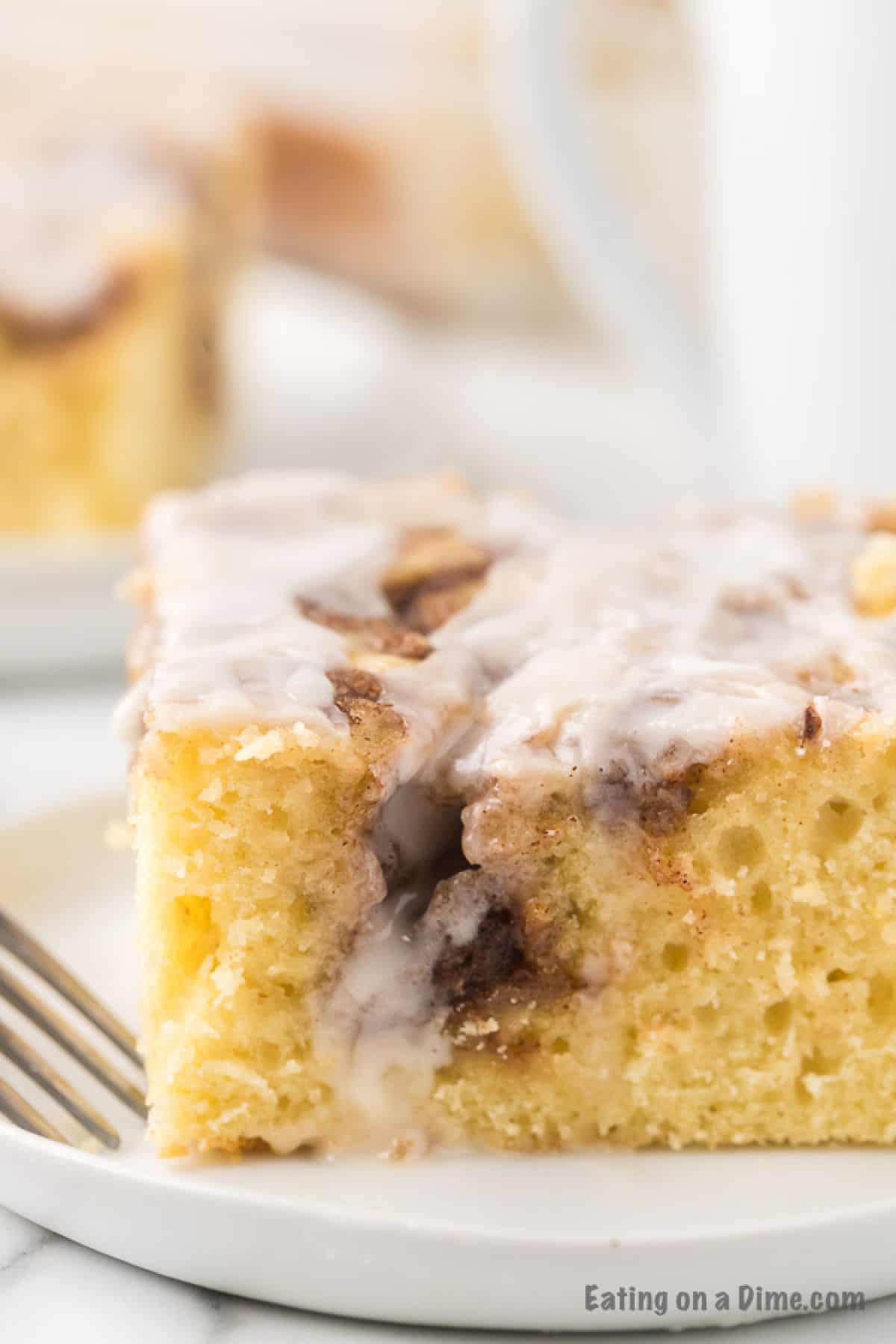 A close up of the cinnamon roll cake on a white plate