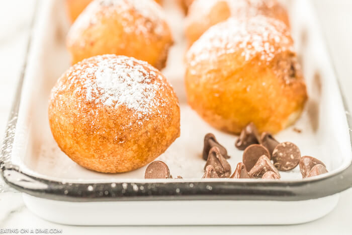 Close up image of deep fried cookie dough on a plate with chocolate chips. 