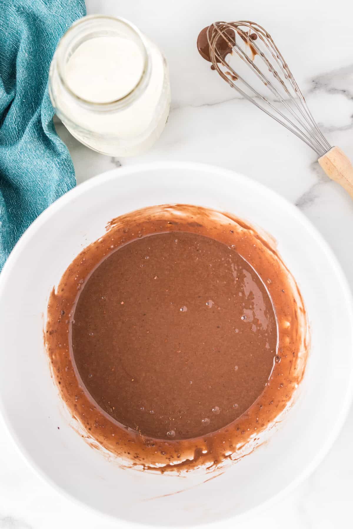Sweetened condensed milk, cocoa powder and vanilla combined in a bowl.