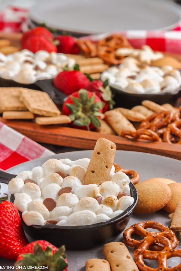smores dip in skillet with graham crackers, pretzels and strawberries.