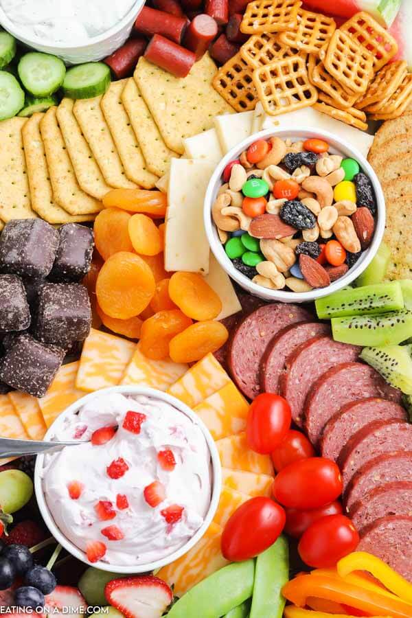 closeup of charcuterie board with salami, crackers, cheese, pretzels and trail mix. 