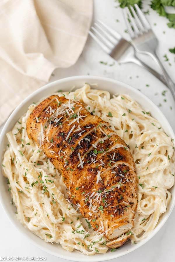 bowl of alfredo with blacked chicken on top