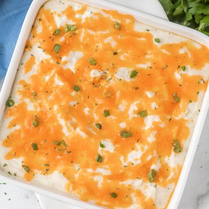 cheesy potatoes in a white casserole dish