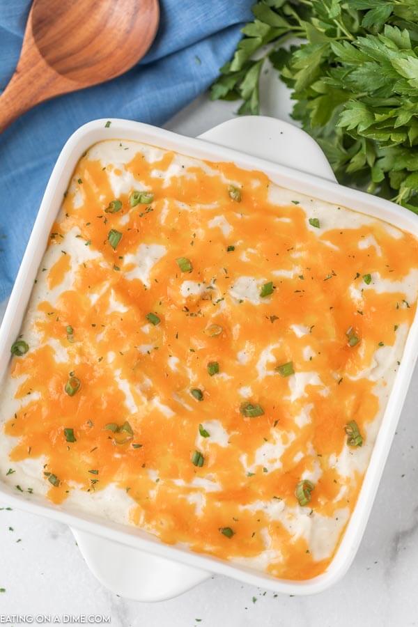 cheesy potato casserole in white baking dish