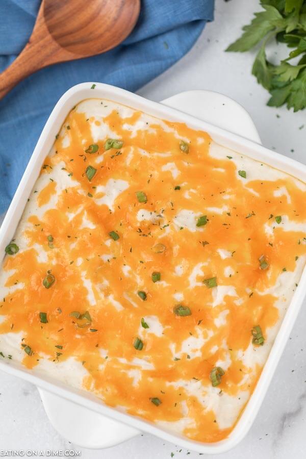 cheesy potatoes in a white casserole dish