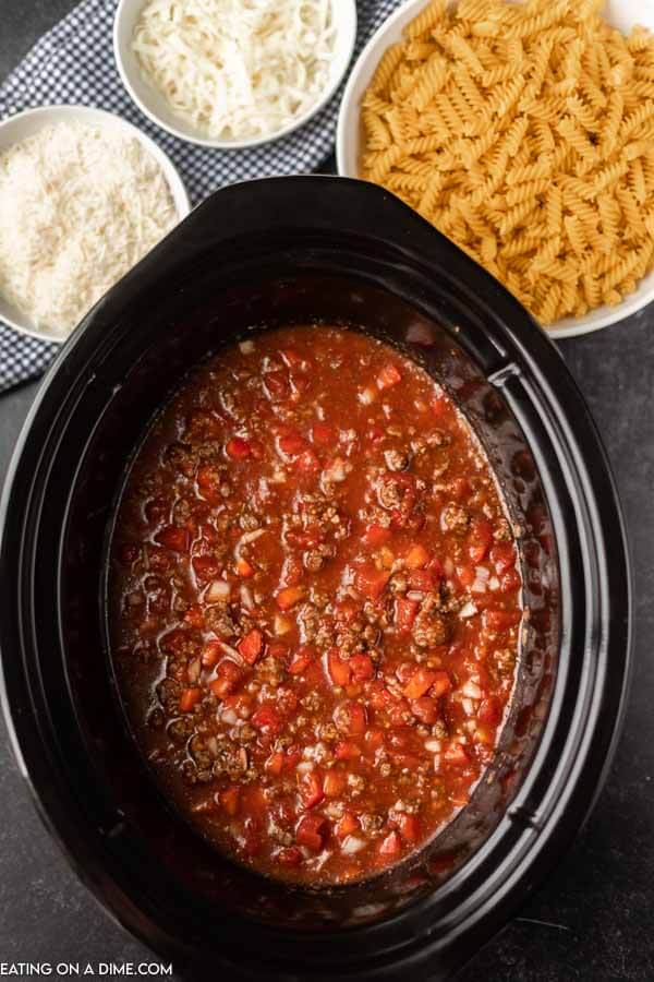 Close up image of lasagna soup in a crock pot before adding in the noodles. 