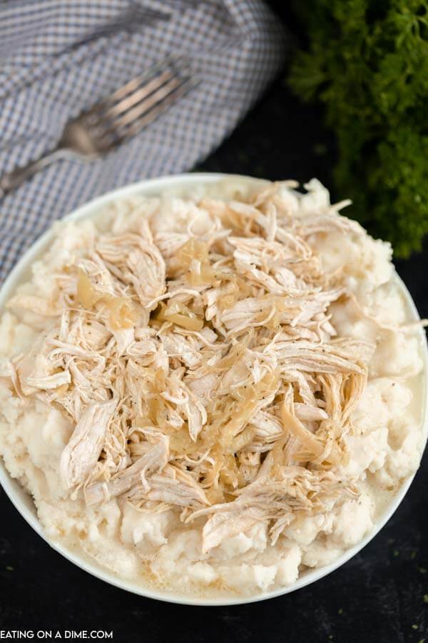 Close up image of Mississippi Chicken in a bowl on mash potatoes. 
