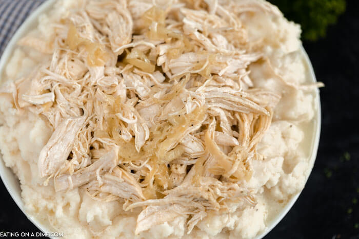 Close up image of Mississippi Chicken in bowl on top of mash potatoes. 