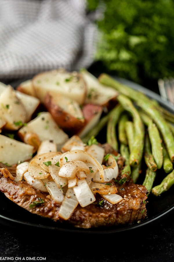 crock pot steak on a plate with green beans and potatoes.