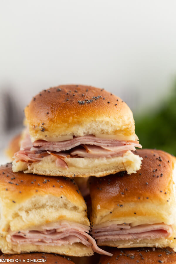 Close up image of ham and cheese slider stacked on top of each other. 