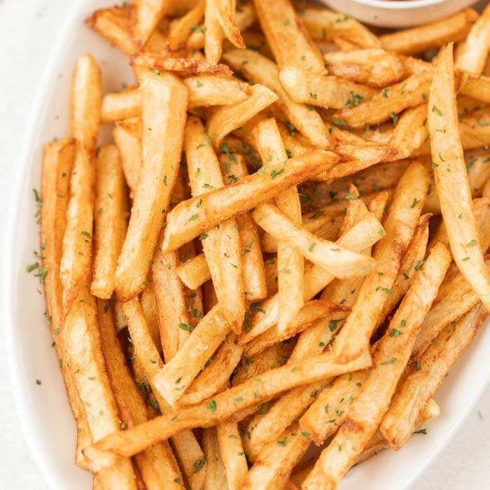 bowl of french fries with parsley on top
