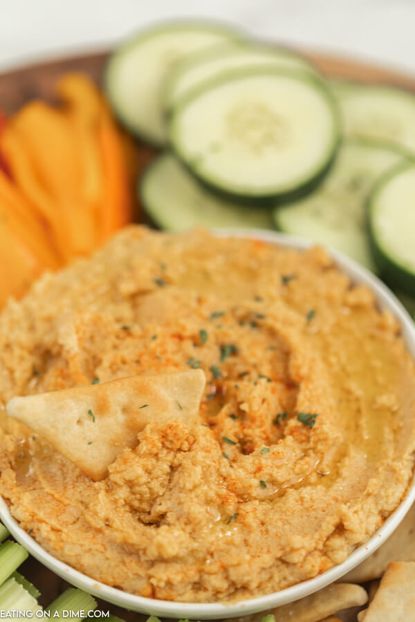 Bowl of hummus with vegetables around it. 