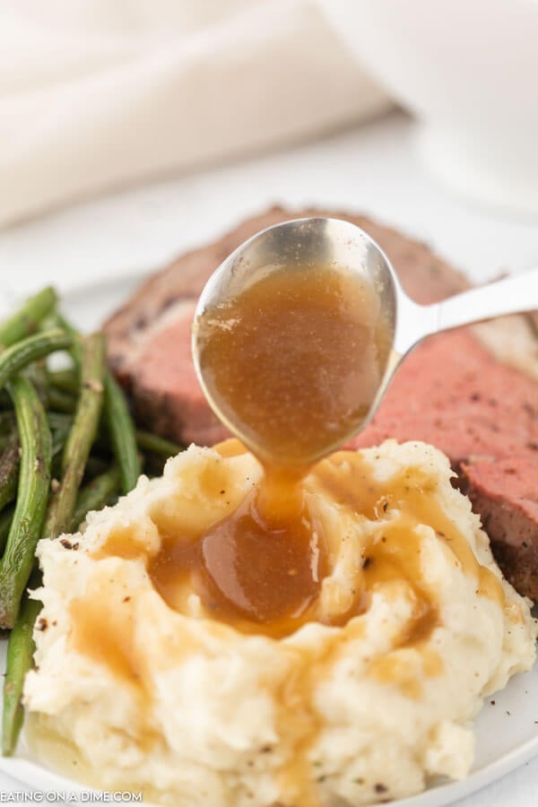 gravy being poured on mashed potatoes