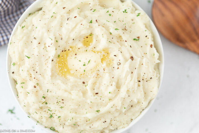 Bowl of mashed potatoes topped with butter. 