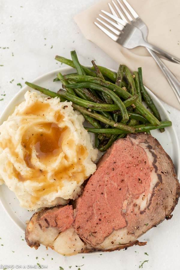 plate of prime rib, green beans and mashed potatoes