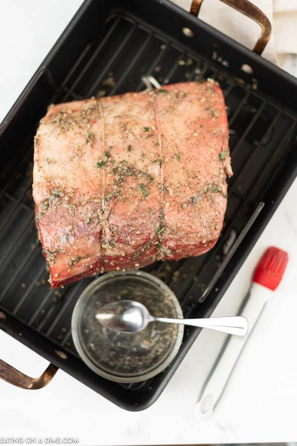 prime rib in roasting pan with spices going on