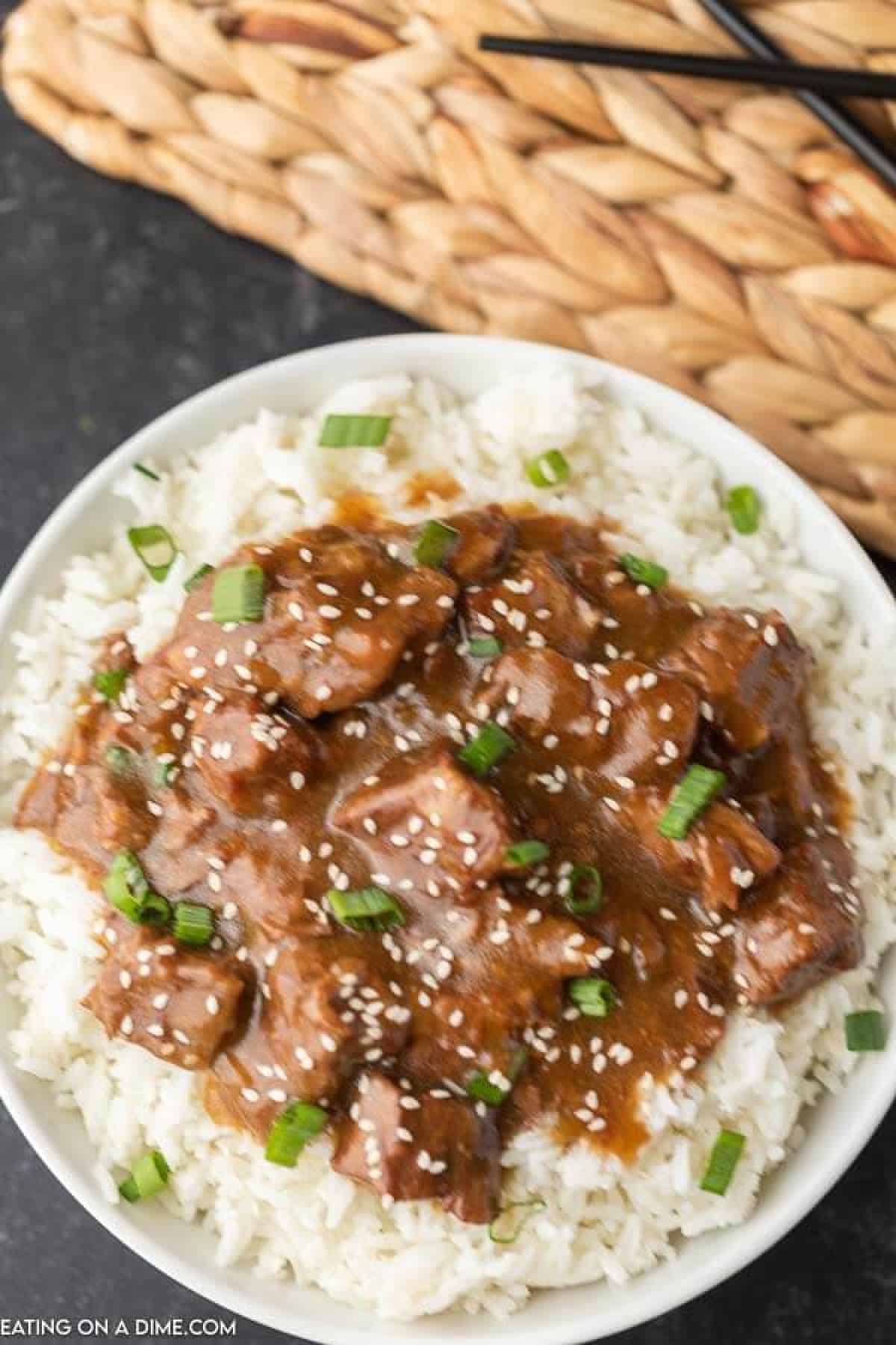 Instant Pot Teriyaki Beef over rice topped with green onions 