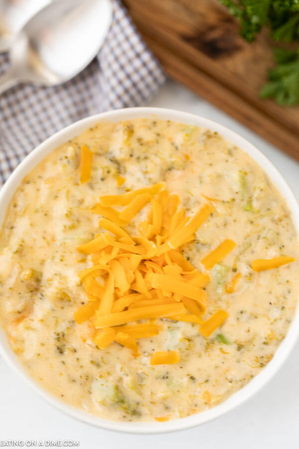 A bowl of broccoli cheese soup with spoon