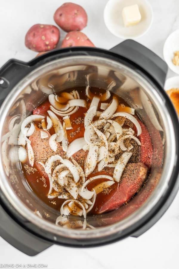 Close up image of steak and onions in the instant pot.