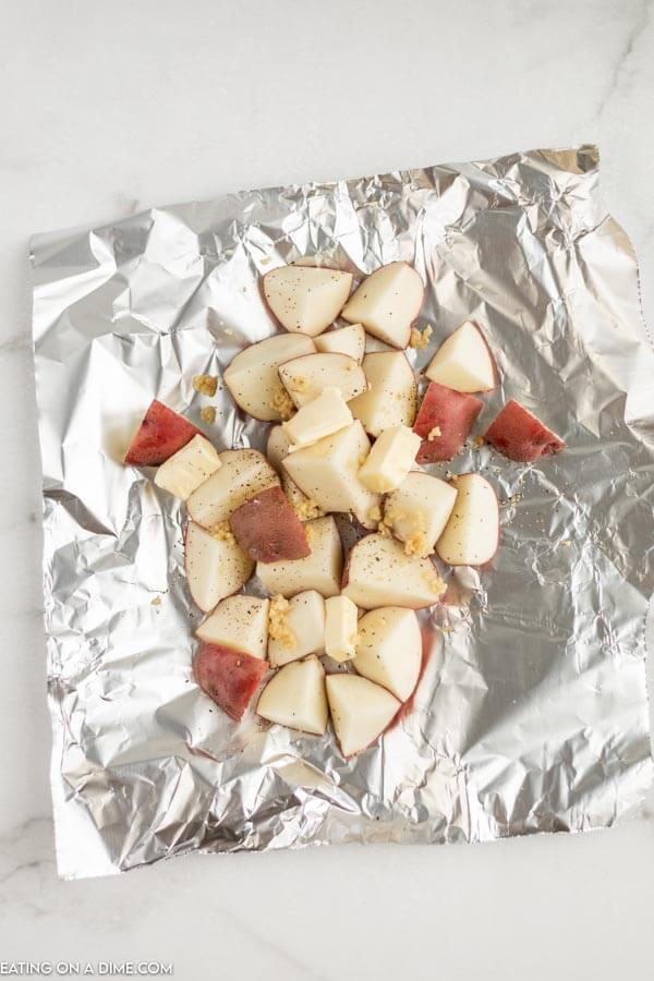 Close up image of foil with potatoes with garlic. 