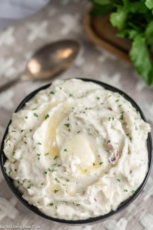 Close up image of ranch mashed potatoes in a black bowl. 