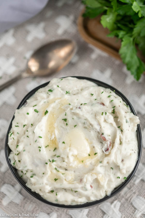 Close up image of ranch mashed potatoes in a black bowl. 